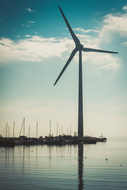 Ländliche Wasserlandschaft mit Arbeitswindkraftanlage