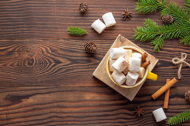 Ländliche Weihnachtskomposition mit einer Tasse Kaffee und Marshmallows auf Holztisch