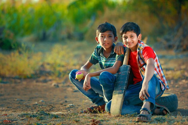 Ländliches indisches Kind, das Cricket spielt