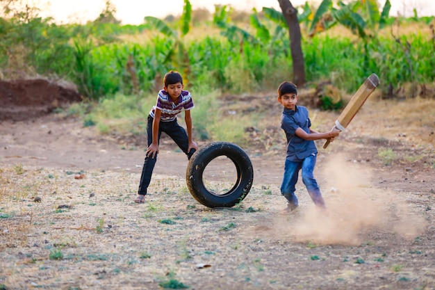 Ländliches indisches Kind, das Cricket spielt