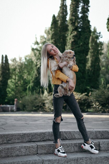 Lärm und Vintage-Stil. Junges Mädchen mit Hund geht in den Park und genießt den schönen Sommertag