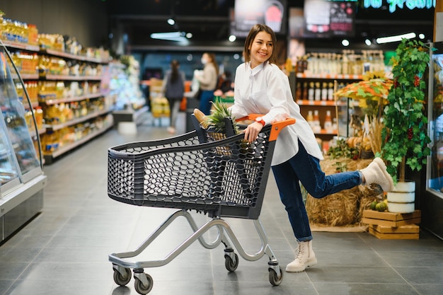 Lässige Frau, die Lebensmittel einkauft und glücklich aussieht