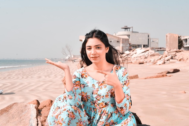 Lässige hübsche Mädchenfronthaltung am Strand, die beiseite zeigt indisches pakistanisches Modell