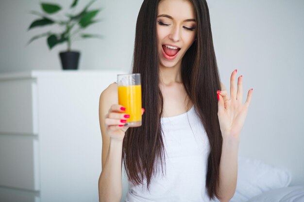 Lässige lächelnde Frau mit einem Glas Orangensaft