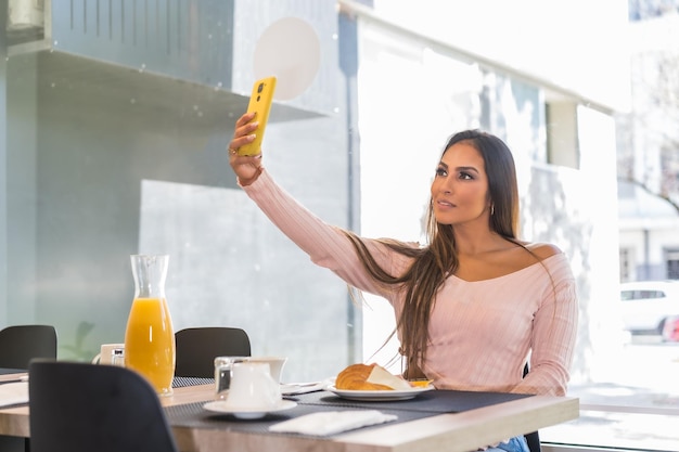 Lässige Schönheitsgeschäftsfrau, die morgens beim Frühstück in einem Luxushotel ein Selfie macht