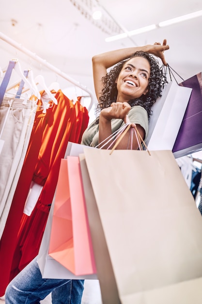 Lässige schwarze Frau im Laden mit Taschen