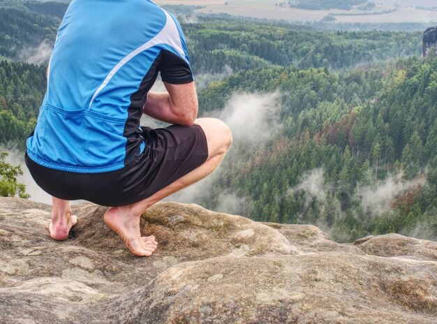 Foto läufer auf dem gipfel wanderer in laufhose und glänzendem blau verschwitzten t-shirt mann in seinem ziel