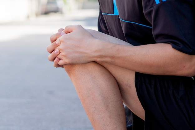 Foto läufer, der schmerzhaftes knie berührt