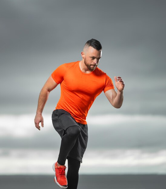 Läufer im Training im Freien, sportlicher Mann, der Fitnessübungen auf dem Ozeanstrand triathlon