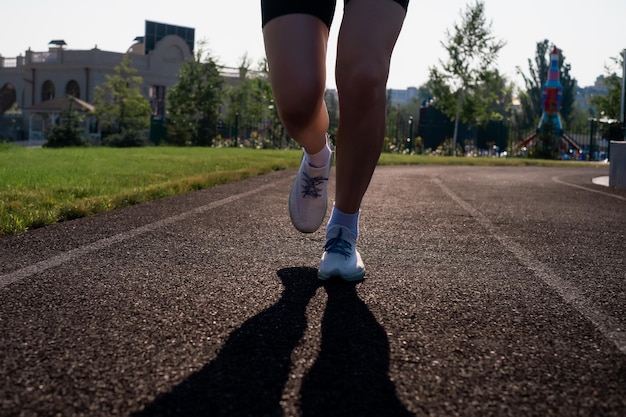 Läuferfüße laufen auf der Straße, Nahaufnahme auf Schuhen, Frau, Fitness, Sonnenaufgang, Joggen, Workout, Wellness