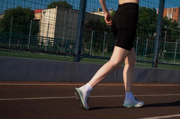 Läuferfüße laufen auf der Straße Nahaufnahme auf Schuhen Frau Fitness Sonnenaufgang Jogging Workout Wellness