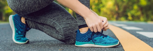 Läuferin bindet ihre Schuhe und bereitet sich auf das Joggen im Freien vor. Sport-Lifestyle-BANNER, langes Format