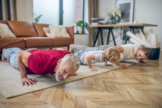 Lagartijas. Dos hombres y su hijo haciendo flexiones y luciendo bien