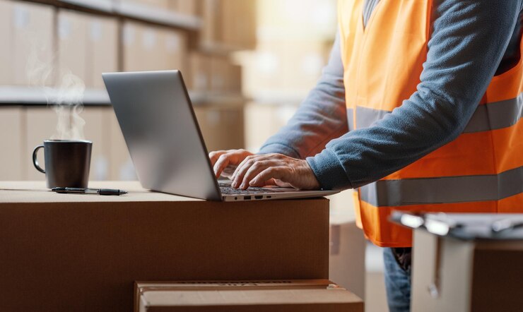 Foto lagerarbeiter arbeitet mit einem laptop