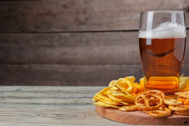 Lagerbier und Imbisse auf Holztisch.