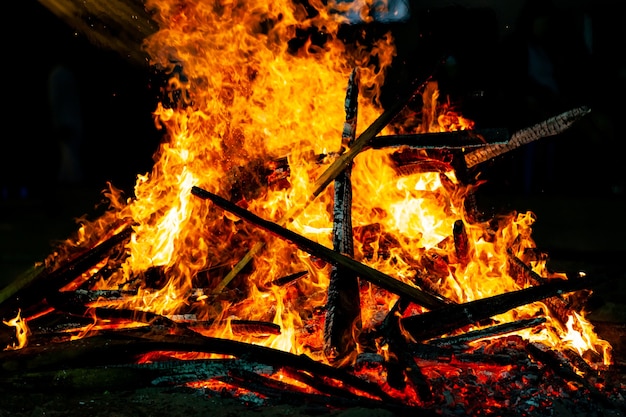 Lagerfeuer, das auf einem dunklen Hintergrund brennt, Holzfeuerflamme.