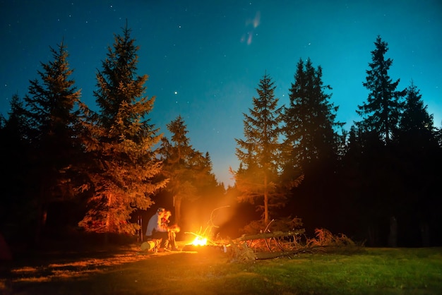 Lagerfeuer im Nachtwald mit Menschen