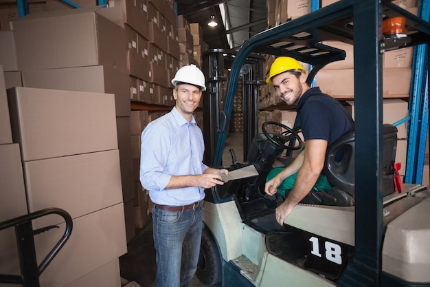 Lagermanager, der mit Gabelstaplerfahrer spricht