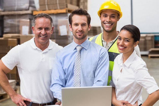 Lagermanager und Arbeitskraft, die an der Kamera lächeln