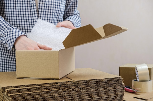 Foto lagermitarbeiter verpackt die bestellung des onlineshops in einen karton