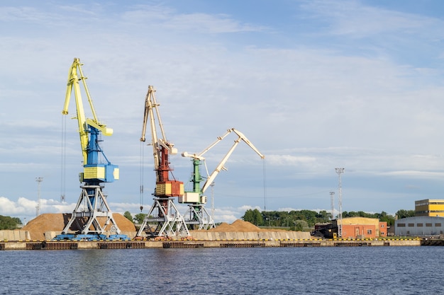 Lagerung, Hafenkran, Industrieszene. Frachtkrane im Terminal im Flussschiffhafen in Ventspils