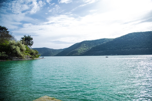 Foto un lago con agua azul, las montañas son visibles a lo lejos. lago abrau, abrau durso. foto de alta calidad