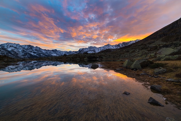 Lago alpino de alta altitude, reflexões ao pôr do sol