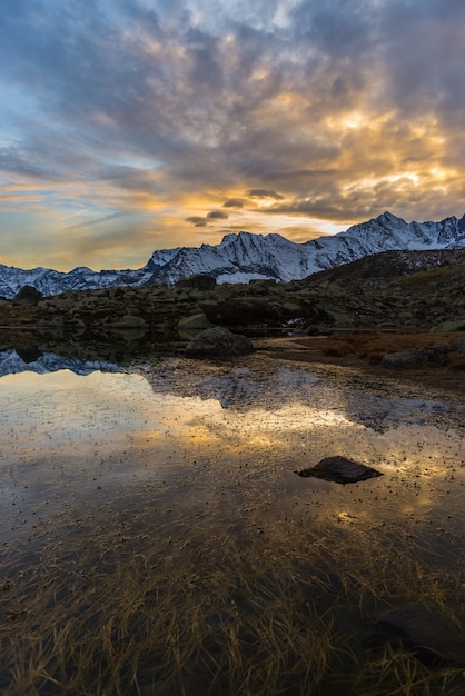 Lago alpino de gran altitud, reflejos al atardecer