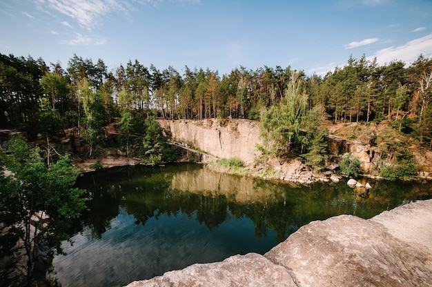 Lago ao fundo de rochas e abetos