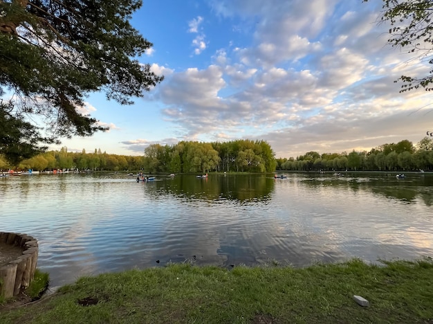 Un lago con árboles y un cielo con nubes.