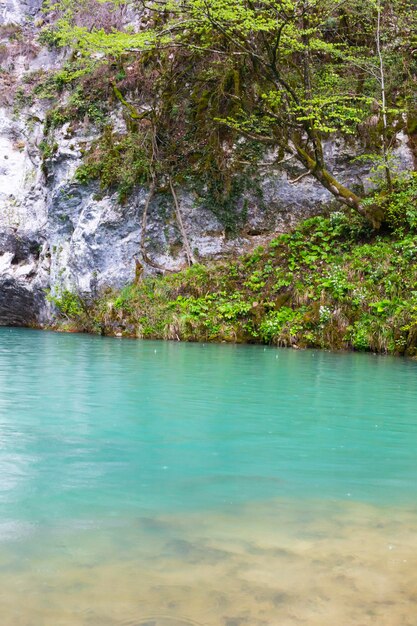 Lago azul montanha Akhtsykh Abkhazia pequeno lago com água turquesa nas montanhas primavera abril