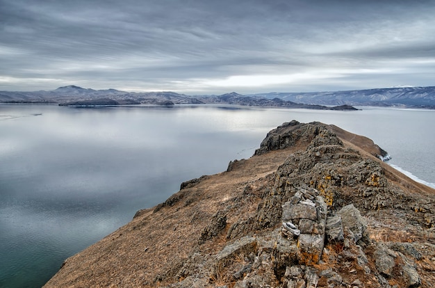 El lago Baikal y Kobilya golova se mecen en el frío de diciembre. Tiempo de congelamiento. Témpanos de hielo está nadando en el agua