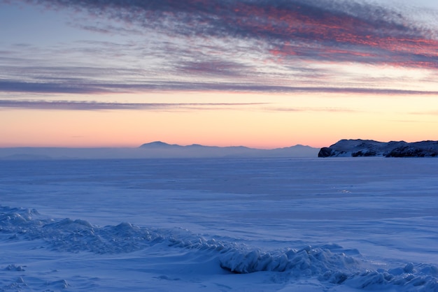 Lago Baikal no inverno coberto de gelo e textura de neve ao pôr do sol na noite da Rússia na Sibéria