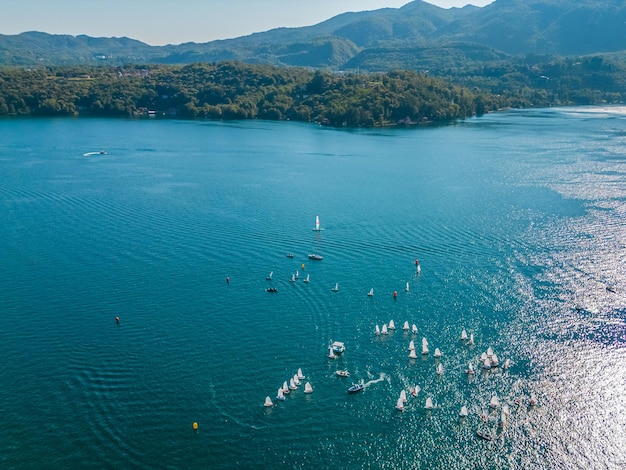 un lago con barcos y veleros en él y una montaña en el fondo