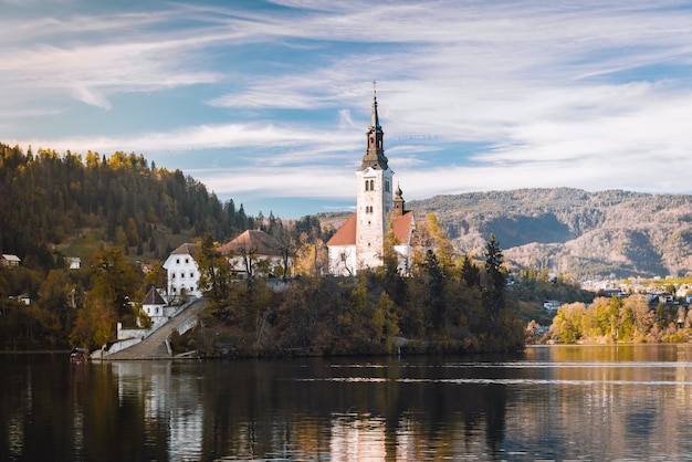 Lago Bled nas montanhas alpinas no outono sob o céu azul