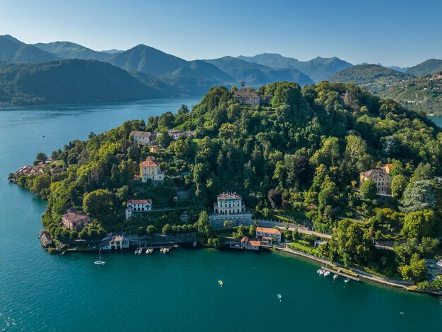 un lago con una casa en la parte superior y un velero en el agua