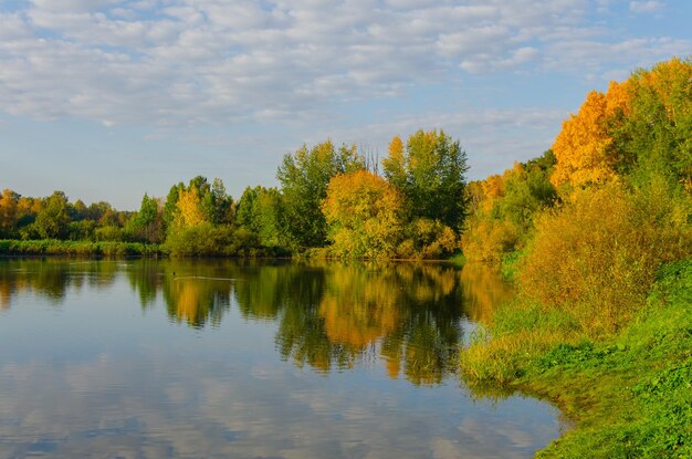 Un lago con colores otoñales en los árboles.