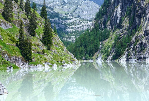 Lago com água turva formou a represa. Paisagem montanhosa de verão (Alpes, Suíça)