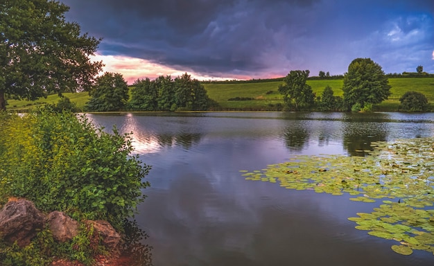 Lago com árvores no pôr do sol na França