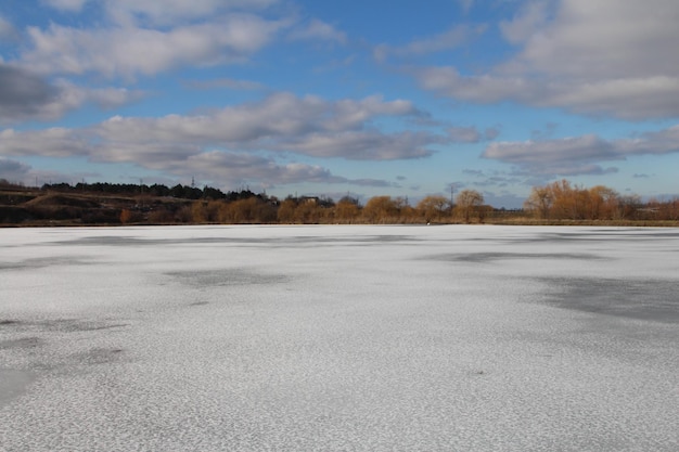 Un lago congelado con árboles en el fondo