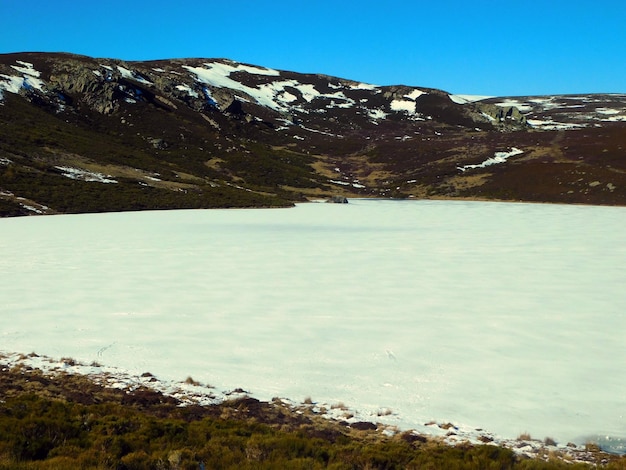 Un lago congelado con nieve en el suelo