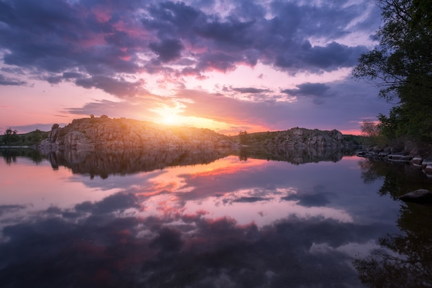 Lago contra o céu colorido com nuvens ao pôr do sol