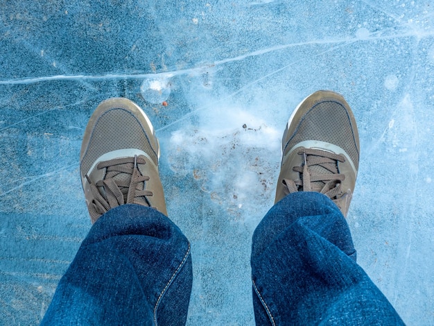 El lago se convierte en hielo en el cráter Kerid Islandia se para sobre él con zapatillas deportivas