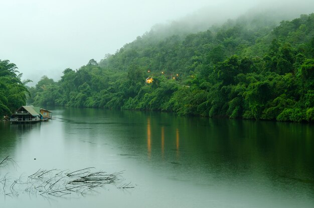 Lago da floresta sob o céu nebuloso azul