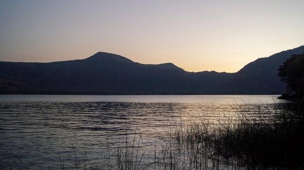 Lago de chapala jalisco méxico ao pôr do sol com reflexo de sol de barcos de pesca no lago méxico