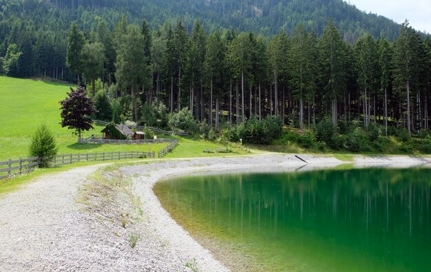 Lago de montanha azul com grama e nuvens de árvores céu azul áustria