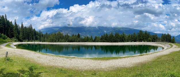 Lago de montanha azul com grama e nuvens de árvores céu azul áustria