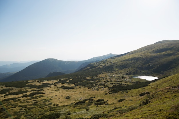 Lago de montanha no alto de montanhas verdes