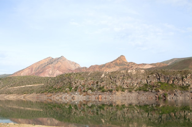 Lago debajo de la montaña durante el día.