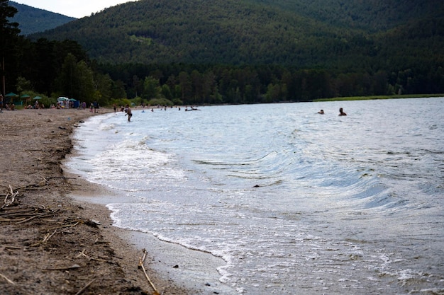 Lago e ao fundo uma montanha. Praia para relaxar em uma área montanhosa.